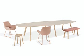 Ovale houten vergadertafel met lichte tafelblad en houten poten, omringd door diverse stoelen in beige/terracotta tinten met