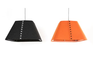 Twee trapeziumvormige hangende lampen in zwart en oranje met stikseldetail op het front en metalen ophangdraden.