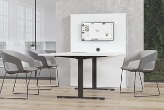 Vergaderruimte met zwarte rechthoekige tafel, vier grijze gestoffeerde stoelen met zwart metalen frame, whiteboard aan wand m