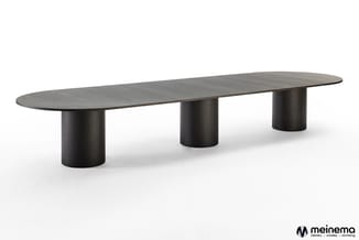 Zwarte vergadertafel met ovaal blad en drie cilindervormige poten op witte achtergrond.