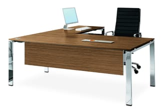 Bruine houten bureau met zilveren metalen poten, monitor, zwarte bureaustoel en accessoires op het blad.