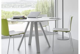 Ronde grijze vergadertafel met vier grijze poten en twee grijze stoelen met groengelke zitting, voor groot raam met uitzicht.