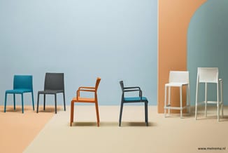 Zes moderne stoelen in verschillende kleuren en modellen in een minimalistische ruimte met blauwe en oranje accenten.