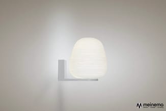 Witte wandlamp met ronde diffuser en grijze metalen beugel op neutrale wand