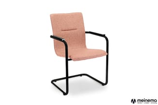 Roze gestoffeerde stoel met zwart metalen U-vormig frame en armsteunen, vrijstaand tegen witte achtergrond.
