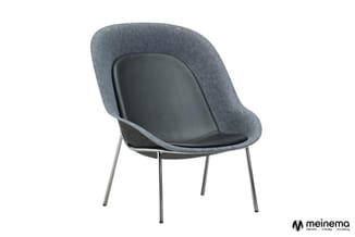 Grijze loungefauteuil met zwart zitgedeelte, gebogende rugleuning en chromen poten, vrijstaand tegen witte achtergrond.