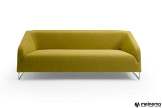 Groene moderne bank met ronde vormen en metallic poten tegen witte achtergrond.