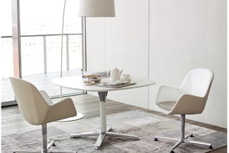 Moderne kantoorruimte met ronde witte tafel, twee witte draaistoelen met beige zitting, vloerlamp, serviesset en raam met uit
