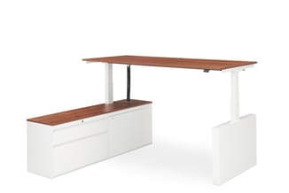 Elektrisch verstelbaar bureau met witte onderstel, houten blad in walnoot, en wit kastje met opbergruimte aan linkerkant.