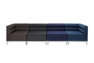 Modulaire bank met vijf zitdelen in verschillende kleuren: bruin, donkergrijs, marineblauw en twee blauwtinten. Witte poten.