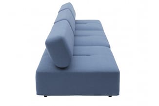 Blauwe loungebank met brede zitting, hoge rugsteun en zijkussen, zijperspectief tegen witte achtergrond.