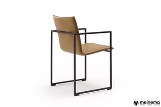 Moderne stoel met caramelkleurig lederen zitting en rugsteun, zwart stalen framewerk, armleuningen, geïsoleerde witte achterg