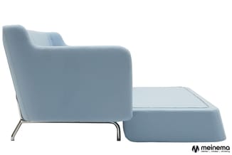 Lichtblauwe fauteuil met bijpassende voetenbankje, geboeid design met metalen poten, zijkant zichtbaar tegen witte achtergron