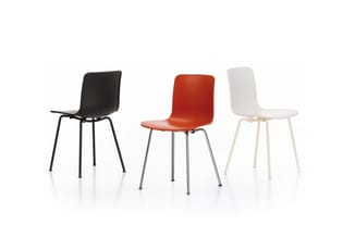 Drie moderne stoelen in zwart, rood en wit met metalen poten op witte ondergrond.