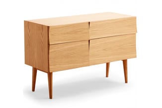 Houten dressoir met vier laden in lichte eikenkleur, op schuine houten poten, geïsoleerd tegen witte achtergrond.