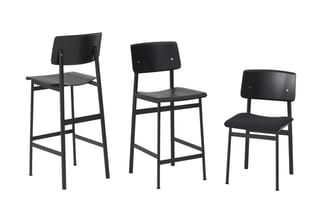 Drie zwarte stoelen met houten zit- en rugleuning op zwart metalen frame: barkruk, counter stool en reguliere stoel.