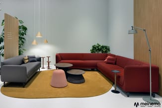 Moderne loungeset met rode hoekbank, grijze sofa, geel rond tapijt, houten tafels, hangende houten lampen en groene planten i