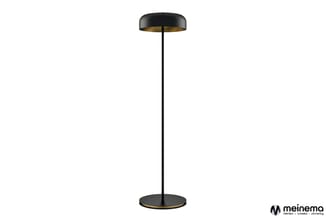 Zwarte staande lamp met messingkleurige binnenkant, ronde voet en slanke stalen paal tegen witte achtergrond.