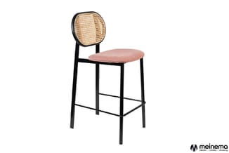 Barkruk met zwart metalen frame, roze gewatteerde zitting en ronde rattan-achterwand tegen witte achtergrond.