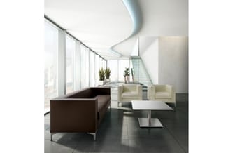 Modern kantoorlounge met bruine hoekbank, crèmekleurige fauteuils, wit salontafel en grote ramen met uitzicht.