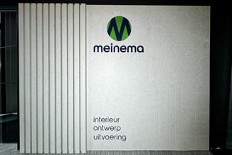 Meinema logo op grijze wandbekleding met verticale lamellen en hexagonale textuur in kantoorruimte.