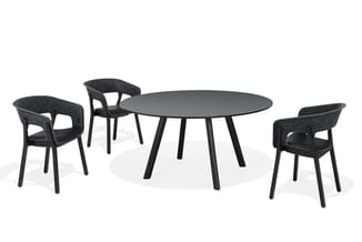 Ronde zwarte tafel met vier zwarte stoelen met grijze bekleding, modern design, geplaatst in vergaderruimte.