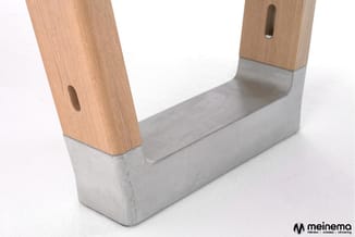 U-vormige poot van houten en betonnen onderstel, voorzien van gaten voor montage.
