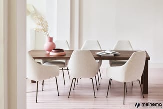 Moderne eetkamer met houten tafel en vijf beige stoelen met metalen poten. Op tafel decoratie en tijdschriften. Roze vaas met