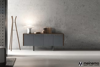 Grijze dressoir met houten bovenblad en zwart metalen onderstel in minimalistisch interieur met betonnen wand en houten staan