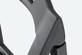 Grijze bureaustoel met textielbekleding en ergonomische rugleuning, detail zijkant.
