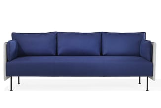 Moderne blauwe bank met drie zitplaatsen, grijze armsteunen, zwarte metalen poten en drie decoratieve kussens.