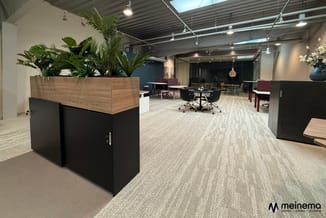 Modern kantoorinterieur met zwarte plantenbak, houten bovenblad, werkplekken, blauwe accent, grijs tapijt en industrieel plaf