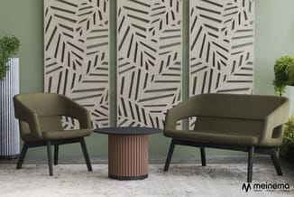 Groene loungezetel en bank met zwarte poten rond ronde tafel in kantoorruimte met groen accent en decoratieve panelen.
