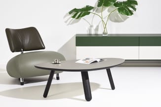 Moderne kantoorinrichting met grijs-zwarte ovale tafel, groen-zwarte leren stoel, groen sideboard en glazen vaas met groene p