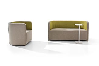 Twee zitmeubelen: links een beige/groen fauteuil met ronde vormen, rechts een beige-groene bank met staande witte lamp.