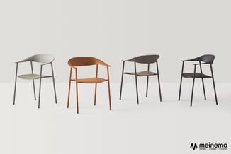 Vier designstoelen in verschillende kleuren: wit met grijs frame, oranje, donkergrijs met zwart frame, en zwart met zwart fra