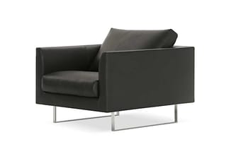 Zwarte leren loungefauteuil met hoge rugleuning en armsteunen, op metalen onderstel.