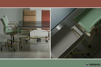 Kantoorwerkomgeving met groene bureaustoel, glazen tafel, houten frame, beige pouf, rode radiator en detail van grijze radiat
