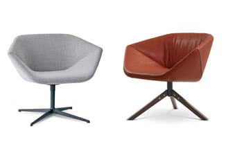Twee moderne fauteuils: links grijze stof op donkerblauwe kruispoot, rechts terracotta leer op bruin houten driepotig onderst