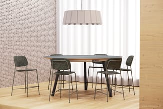 Houten vergadertafel met grijze barstoeLen, beige hanglamp, roze gestippeld behang en houten vloer in moderne kantoorruimte.