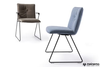 Twee moderne stoelen met metalen frame: grijsbruine stoel met armleuningen en blauwe stoel zonder armleuningen, beide met gev