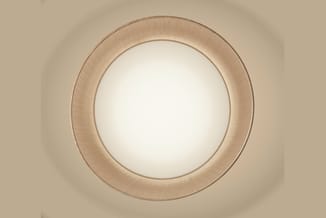 Ronde plafondlamp met textuurgestructureerde beige rand en melkwit diffuseroppervlak tegen neutral gekleurde muur.