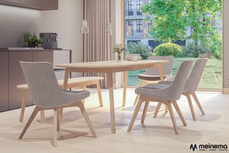 Houten eettafel met grijze stoelen in moderne keuken-eetkamer met raam, uitzicht op groen en hangende verlichting.