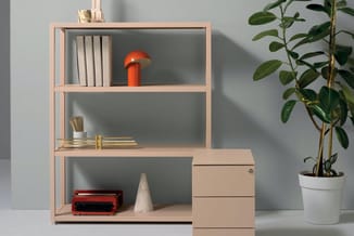 Lichthouten open kastenstelsel met drie vakken, gevuld met boeken, rode lamp en typewriter. Aansluitend houten ladeblok. Naas
