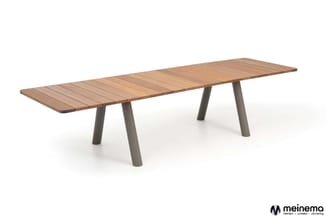 Lange vergadertafel met houten blad in naturel tint en grijze conische poten, rechthoekige vorm.