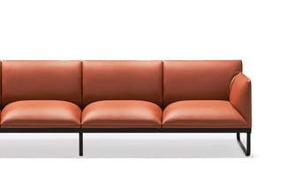 Driezits bank met terracotta lederen bekleding en zwart metalen onderstel, zijaanzicht.