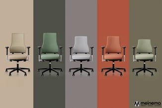 Vijf ergonomische bureaustoelen in verschillende kleuren (beige, groen, wit, oranje, lichtgroen) tegen gekleurde achtergronde