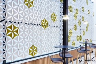 Moderne kantoorruimte met geometrische wandpanelen in wit, goud en navy, zwarte hanglamp, houten vloer en minimalistisch inge