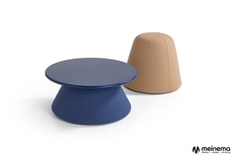 Blauwe paddenstoelvormige salontafel met plat blad naast beige conische poef, beide bekleed met stof.
