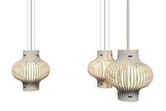 Hangende verlichting met ribbelstructuur in betonlook. Links één pendant, rechts drie pendellampen in verschillende grootte g
